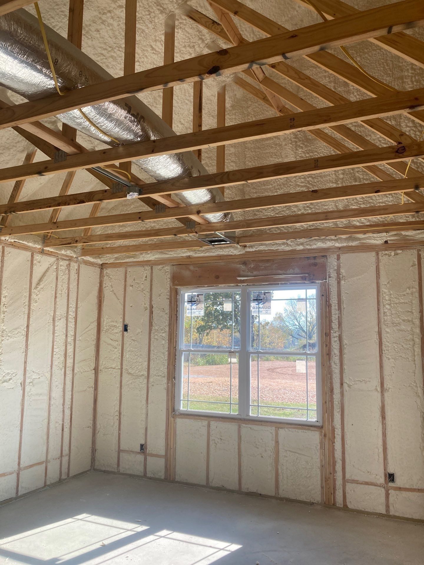 A room with a window and a ceiling that is being built.