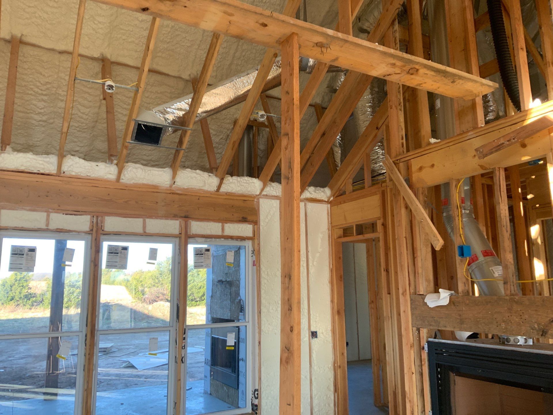 A house is being built with a lot of windows and a fireplace.