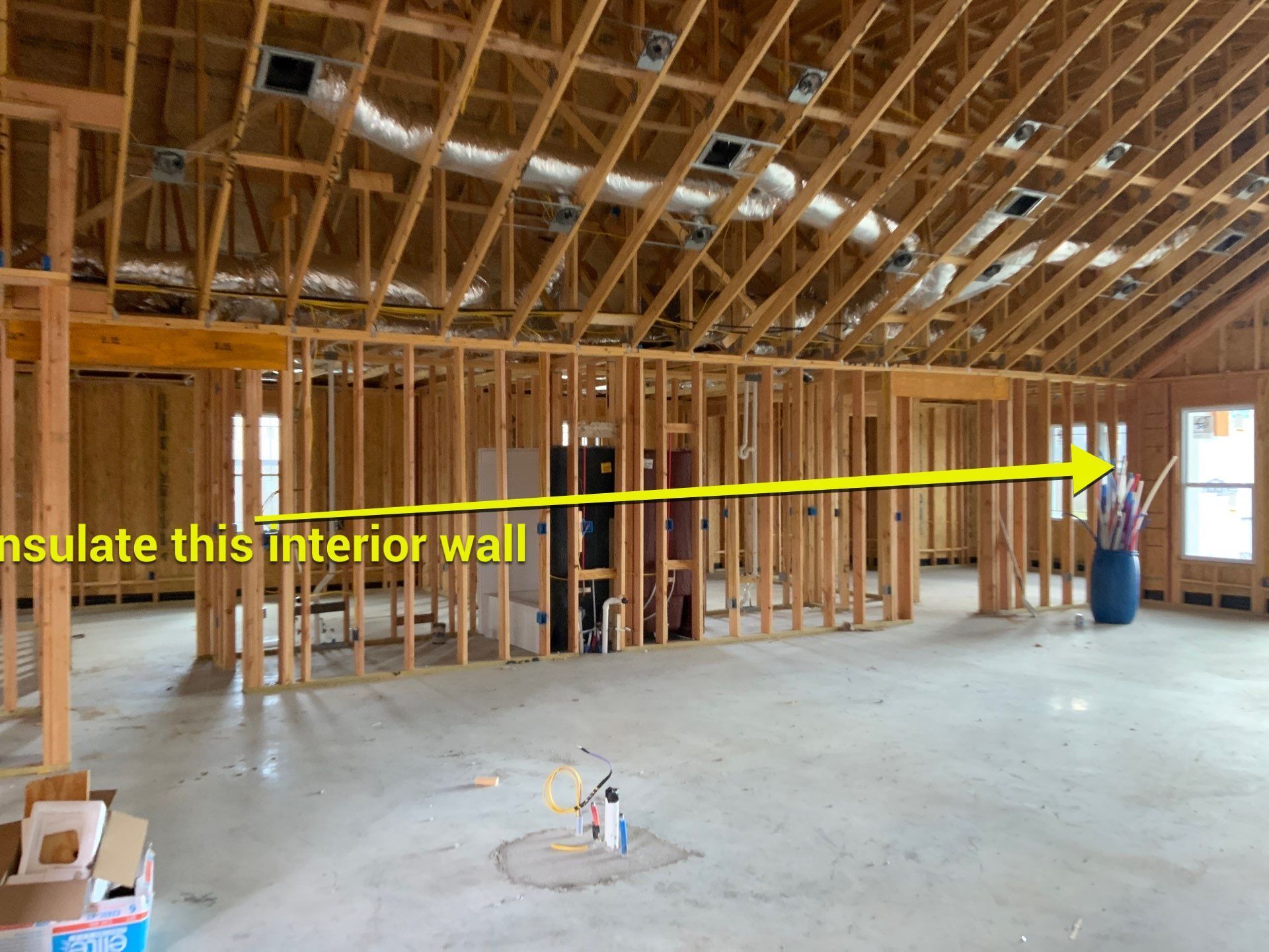 A picture of a building under construction with an arrow pointing to the interior wall.