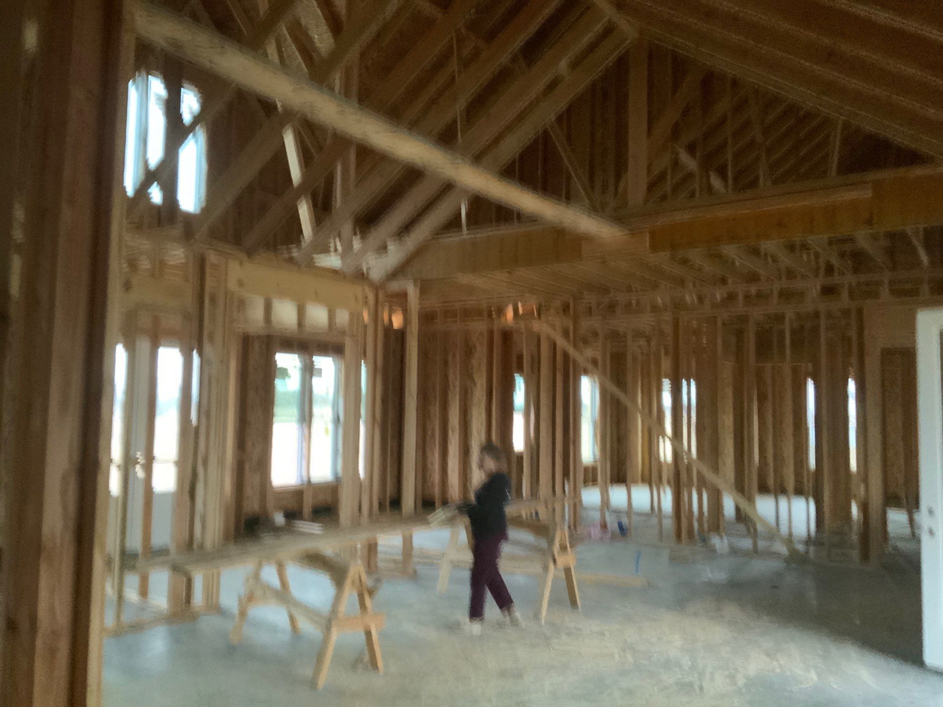 A person is standing in the middle of a building under construction.