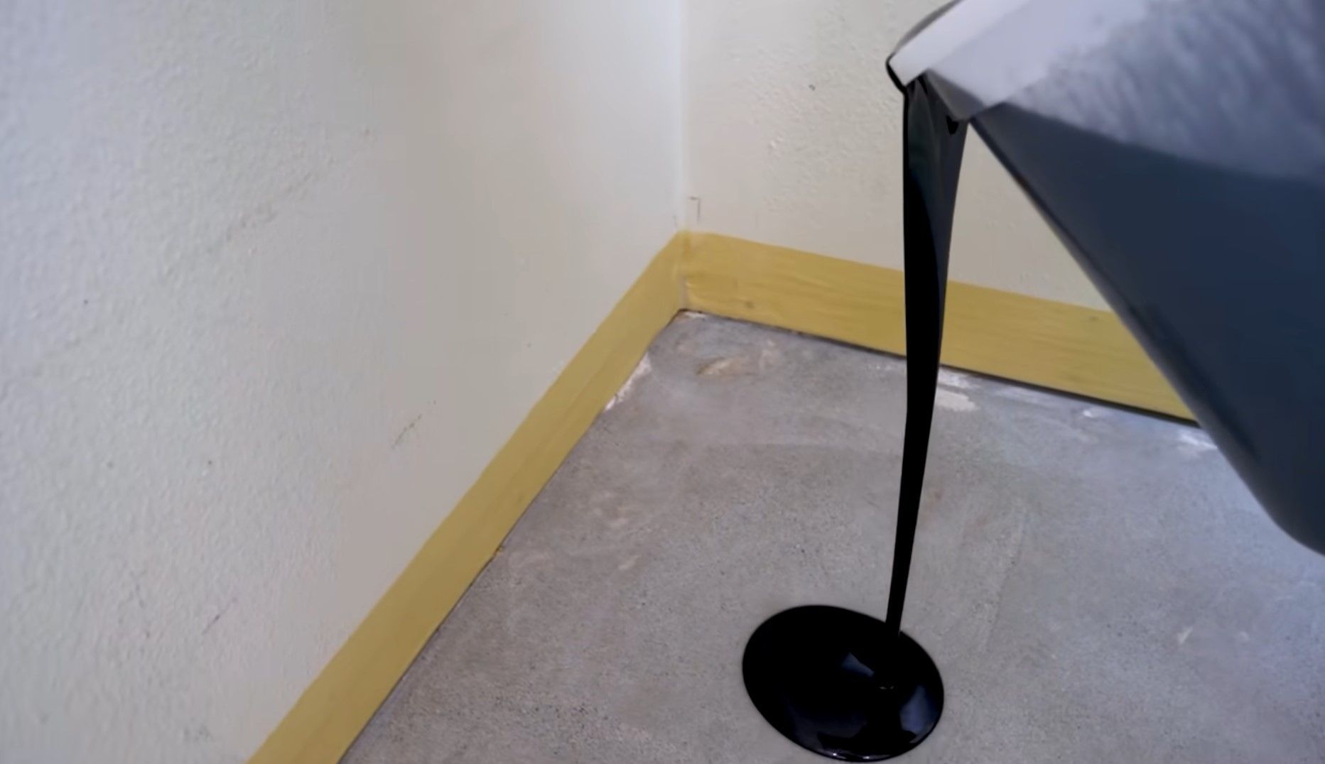 pouring black epoxy over concrete