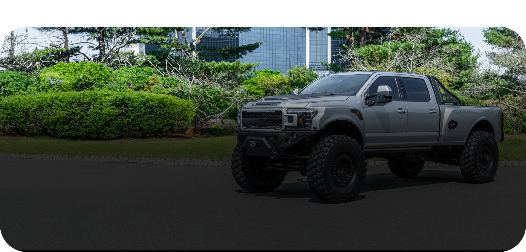 A white car is raised on a red lift in an auto repair shop.