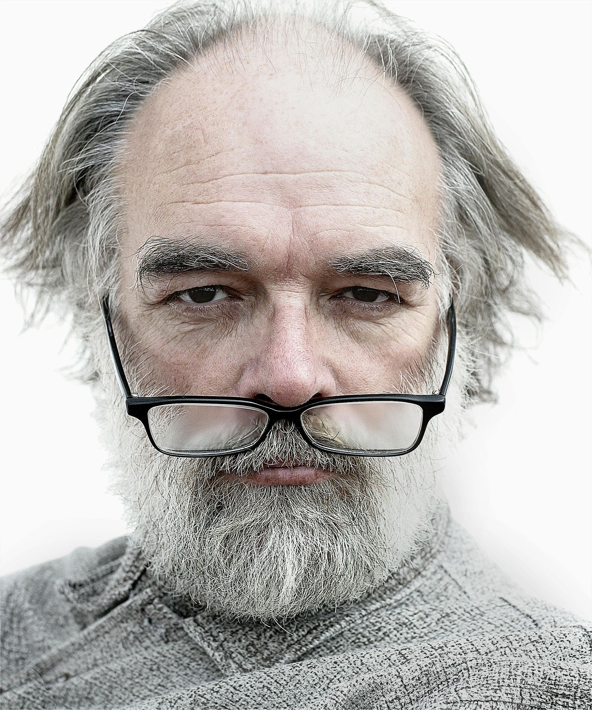 Man with frosty white beard and eyebrows, wearing glasses, looking at the viewer.