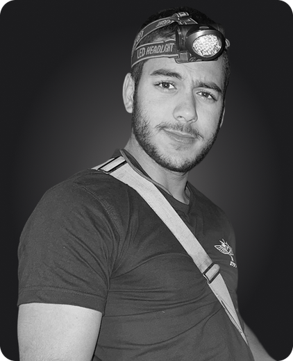 A black and white photo of a man wearing a headlamp