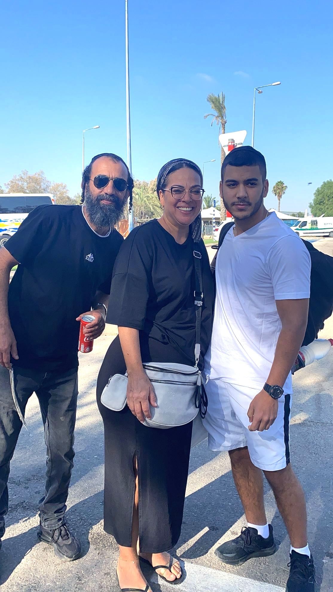 A group of people standing next to each other on a street.