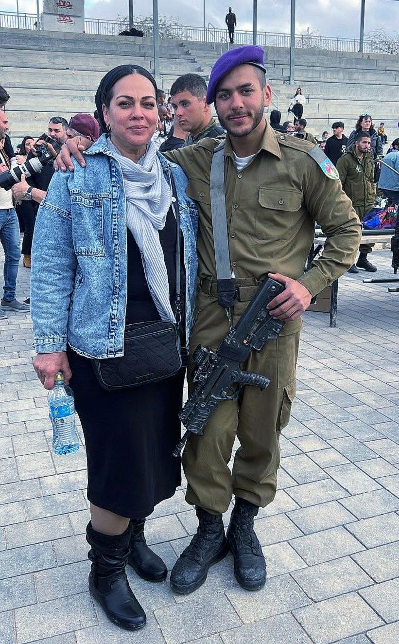 A man in a military uniform is posing for a picture with a woman.