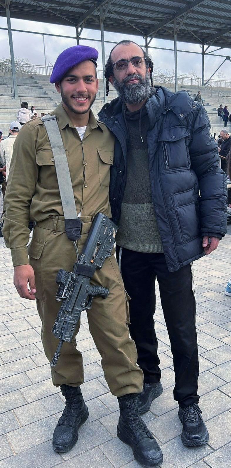 Two men in military uniforms are posing for a picture.