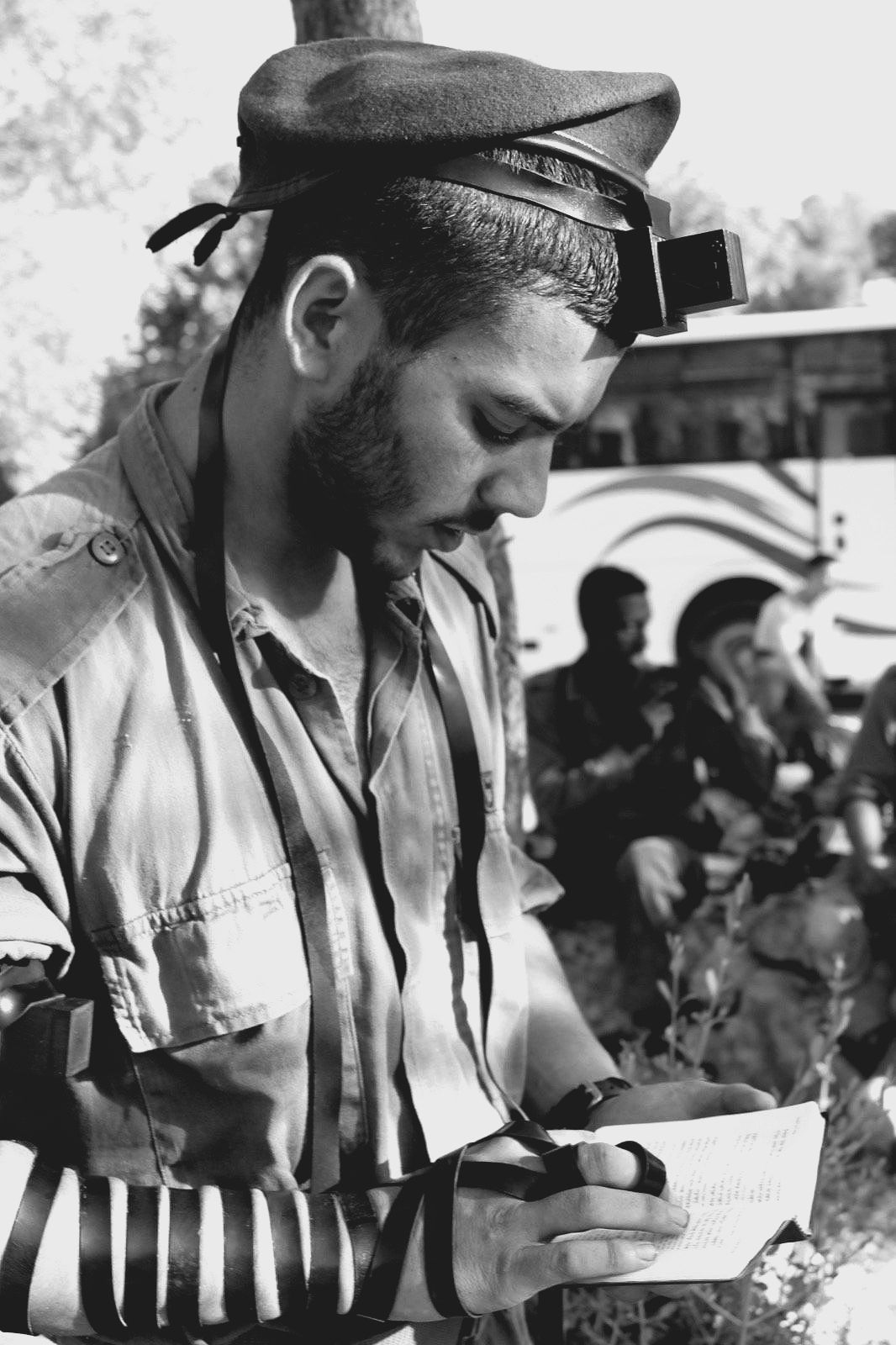 A man in a military uniform is writing on a piece of paper