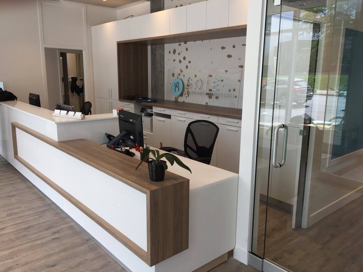 Un bureau d'accueil dans un cabinet dentaire avec un ordinateur dessus.