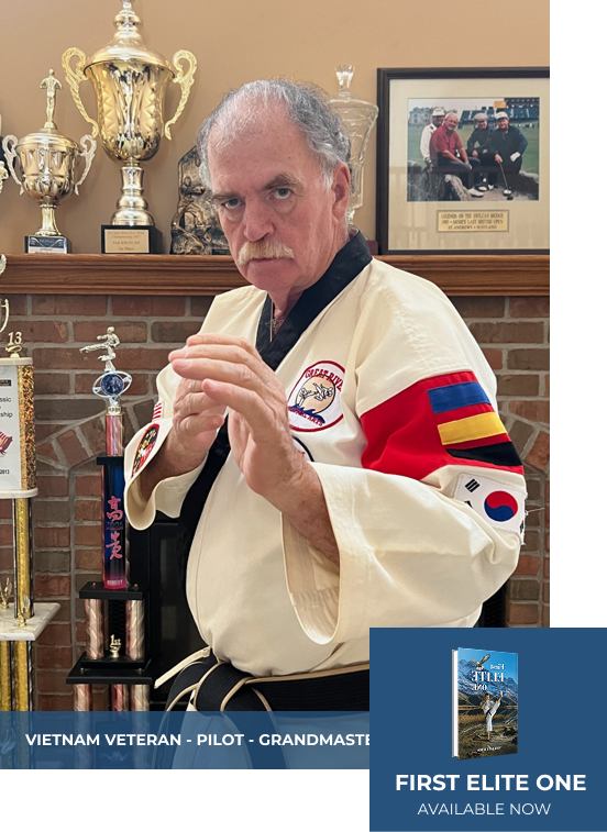 Martial artist in uniform, black belt, hands up. Trophies in background. 