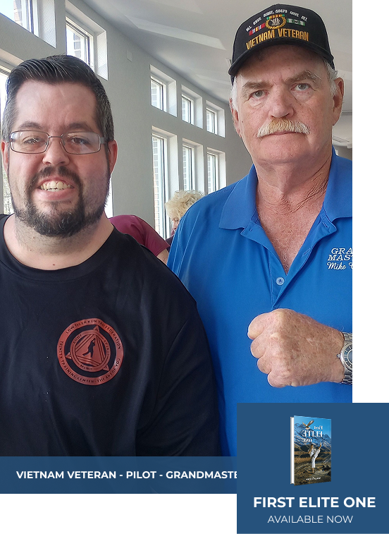 Two men posing for a photo, one wearing a Vietnam Veteran hat.