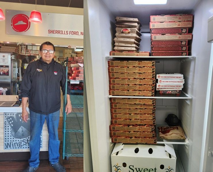 A man standing in front of a stack of pizza boxes