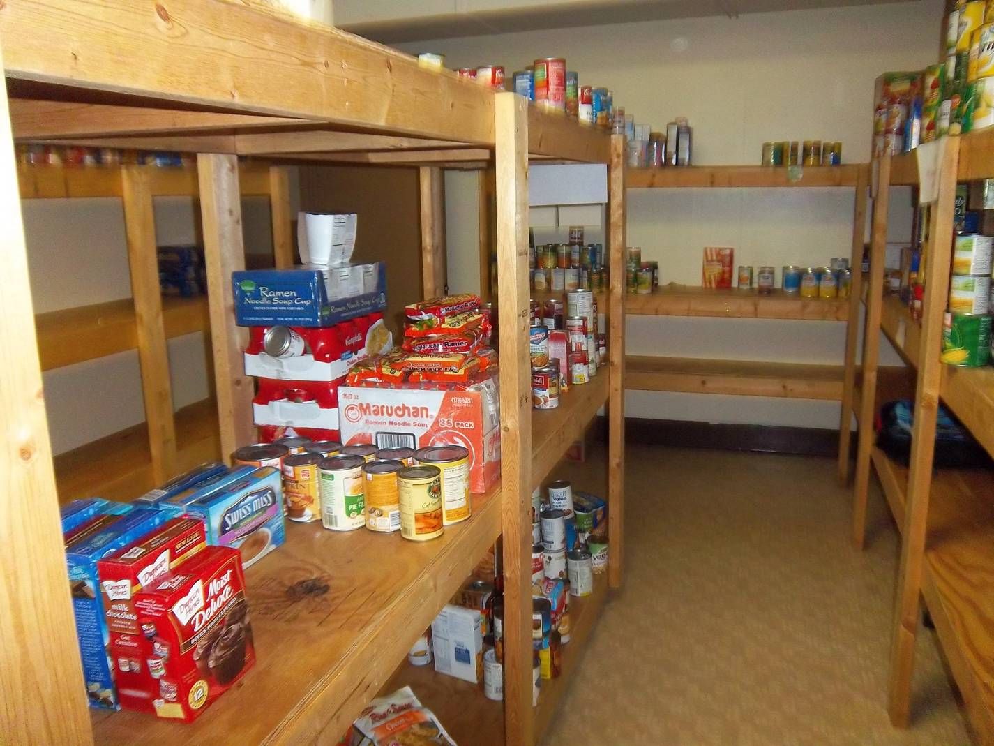 A pantry filled with lots of food including a box of pepsi max