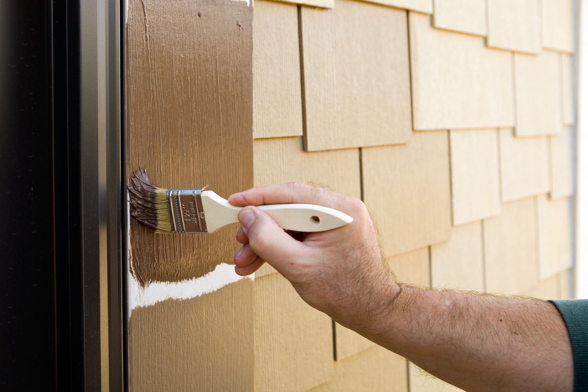 A person is painting a door with a brush.