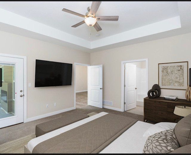 A bedroom with a large bed and a flat screen tv on the wall