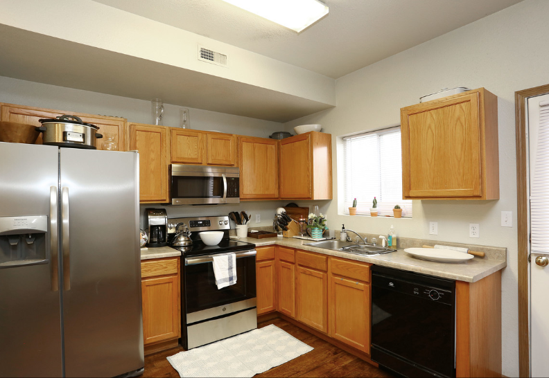 A kitchen with stainless steel appliances and wooden cabinets
