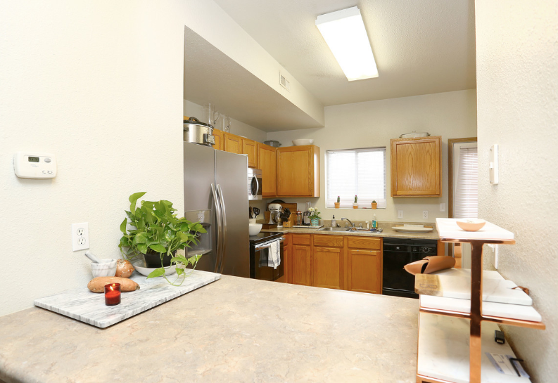 A kitchen with stainless steel appliances and wooden cabinets