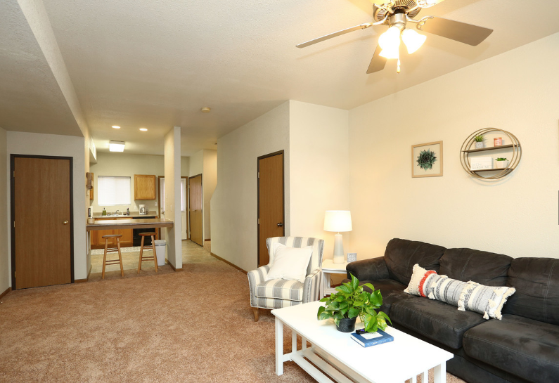 A living room with a black couch and a white coffee table