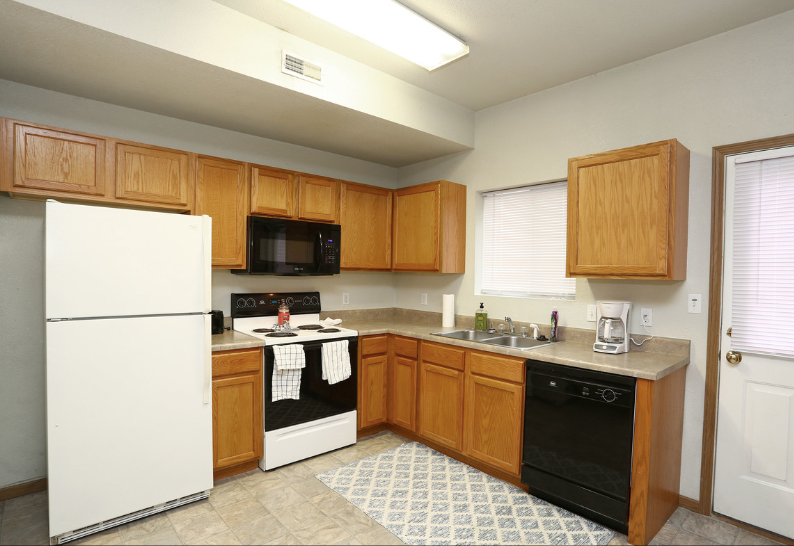A kitchen with wooden cabinets and a white refrigerator