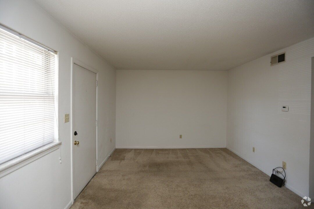 An empty living room with a window and a door