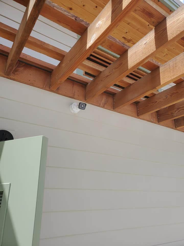 A camera is hanging from the ceiling of a wooden structure.