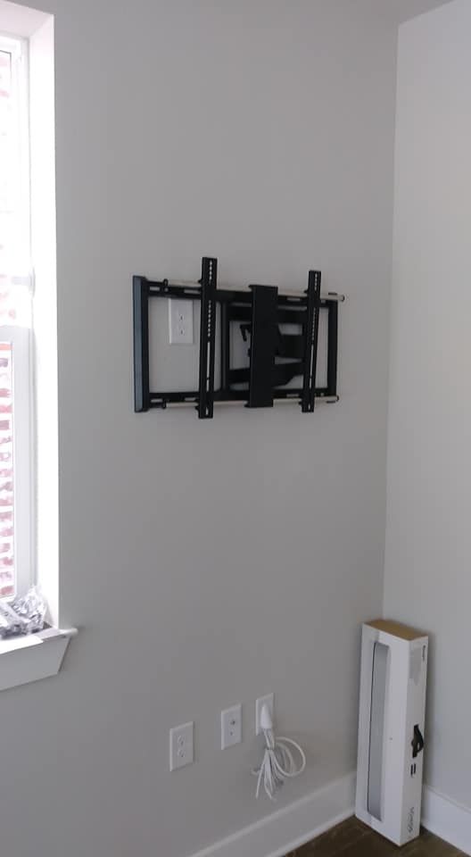 A flat screen tv mounted on a wall next to a window.