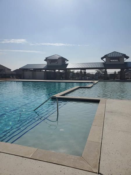 A large swimming pool with a building in the background