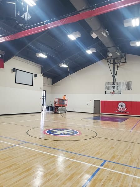An empty basketball court with a cross in the middle