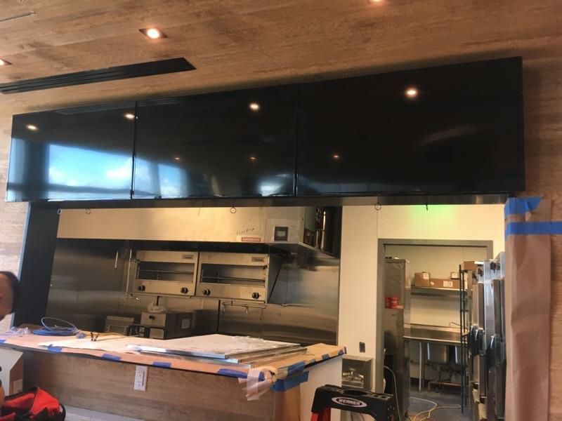 A kitchen with black cabinets and stainless steel appliances