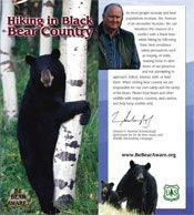 Black bear near a tree with text 