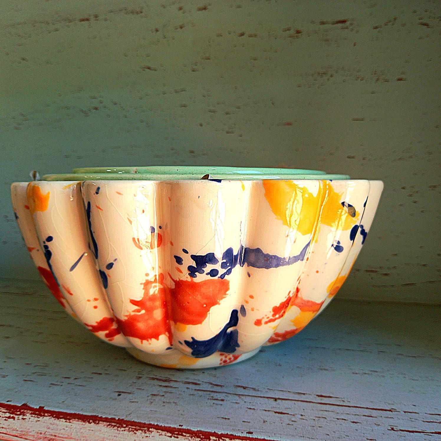 Un cuenco colorido reposa sobre un estante de madera.