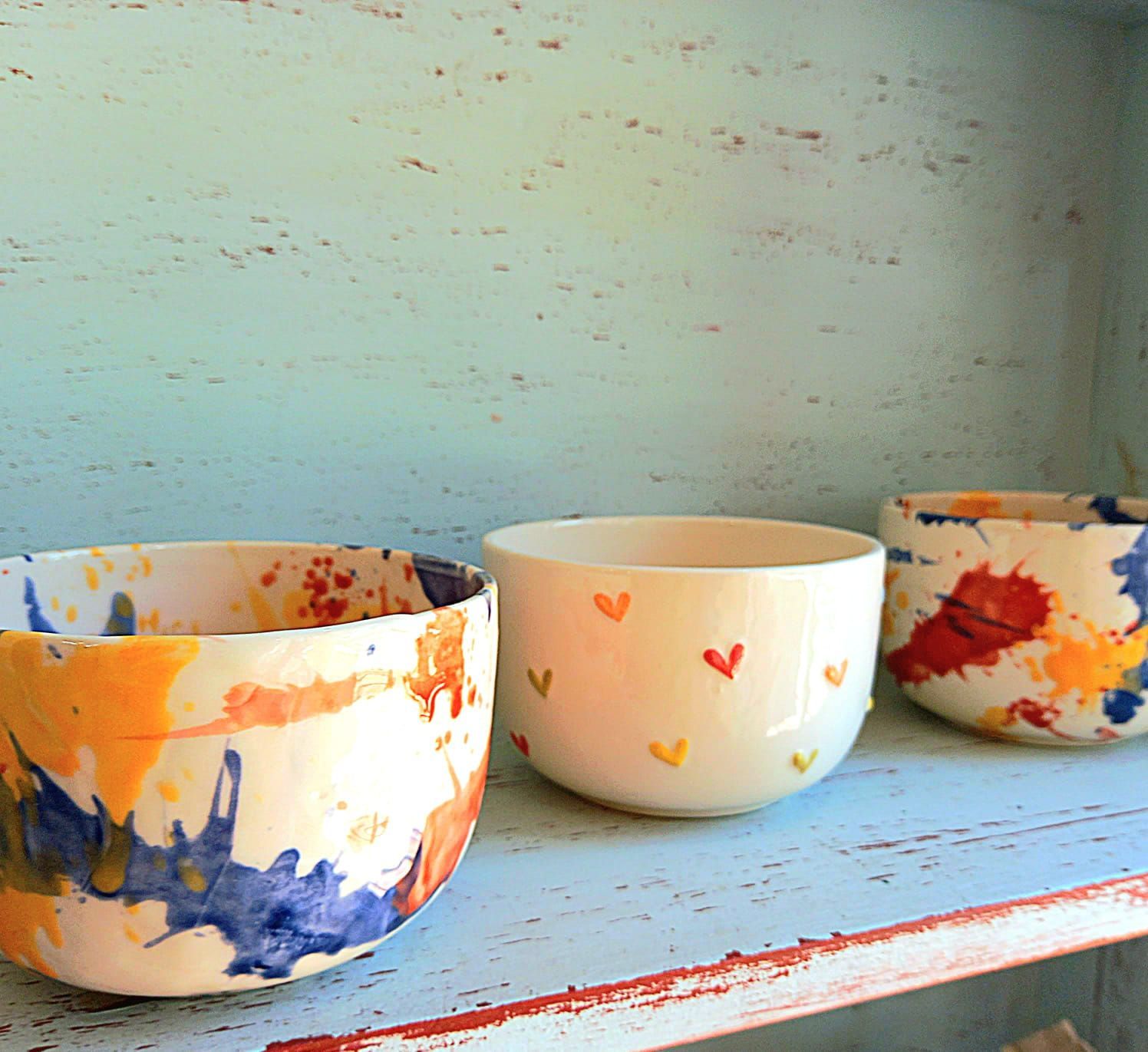 Dos cuencos con corazones pintados están sobre una mesa.