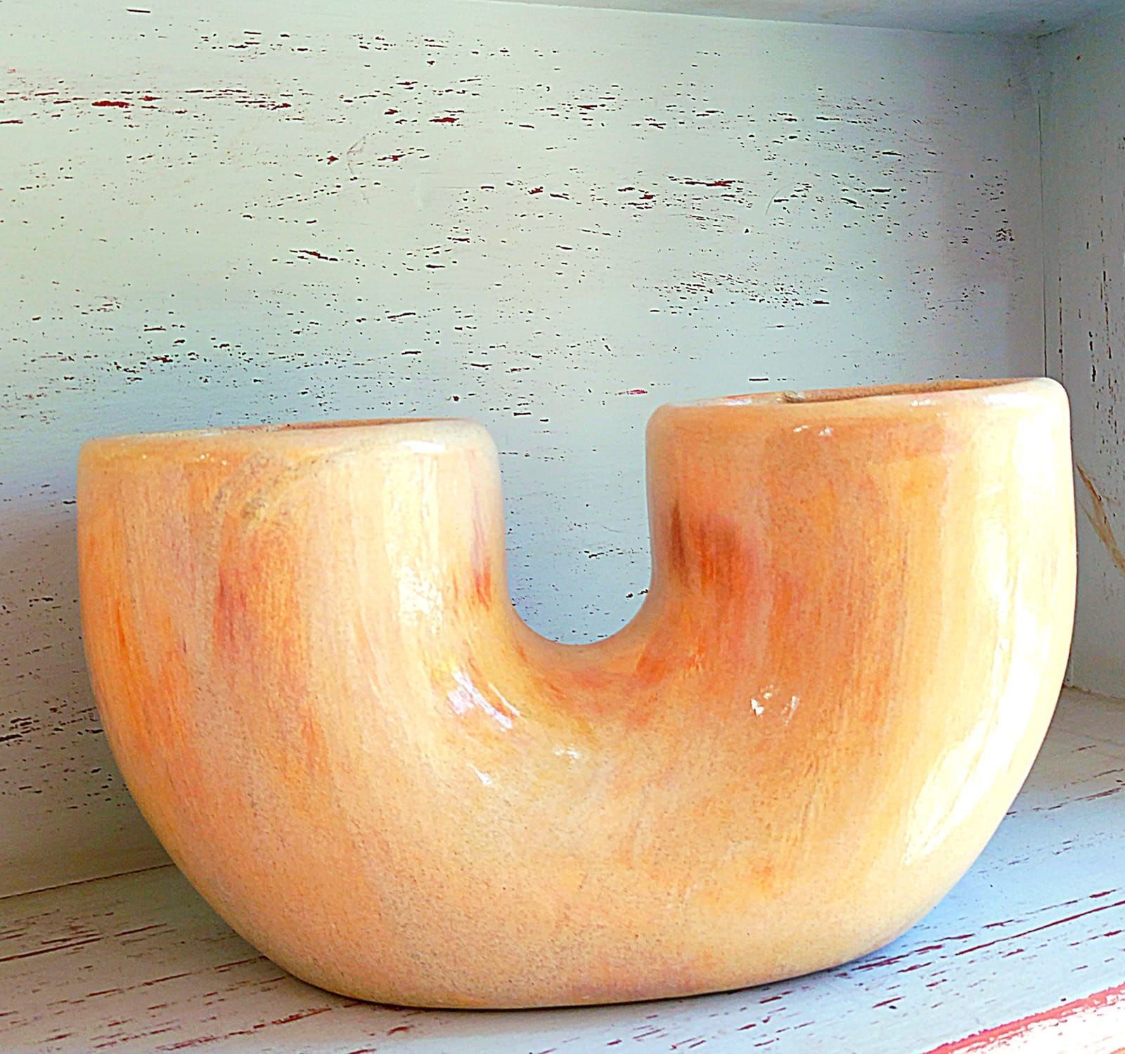 Un cuenco de madera se encuentra sobre un estante blanco.