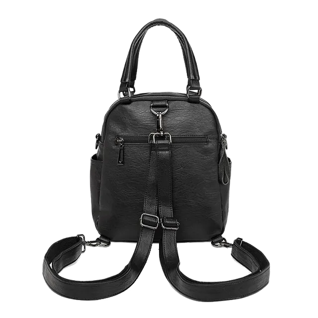 Mochila de piel negra con dos correas de hombro y asa superior.