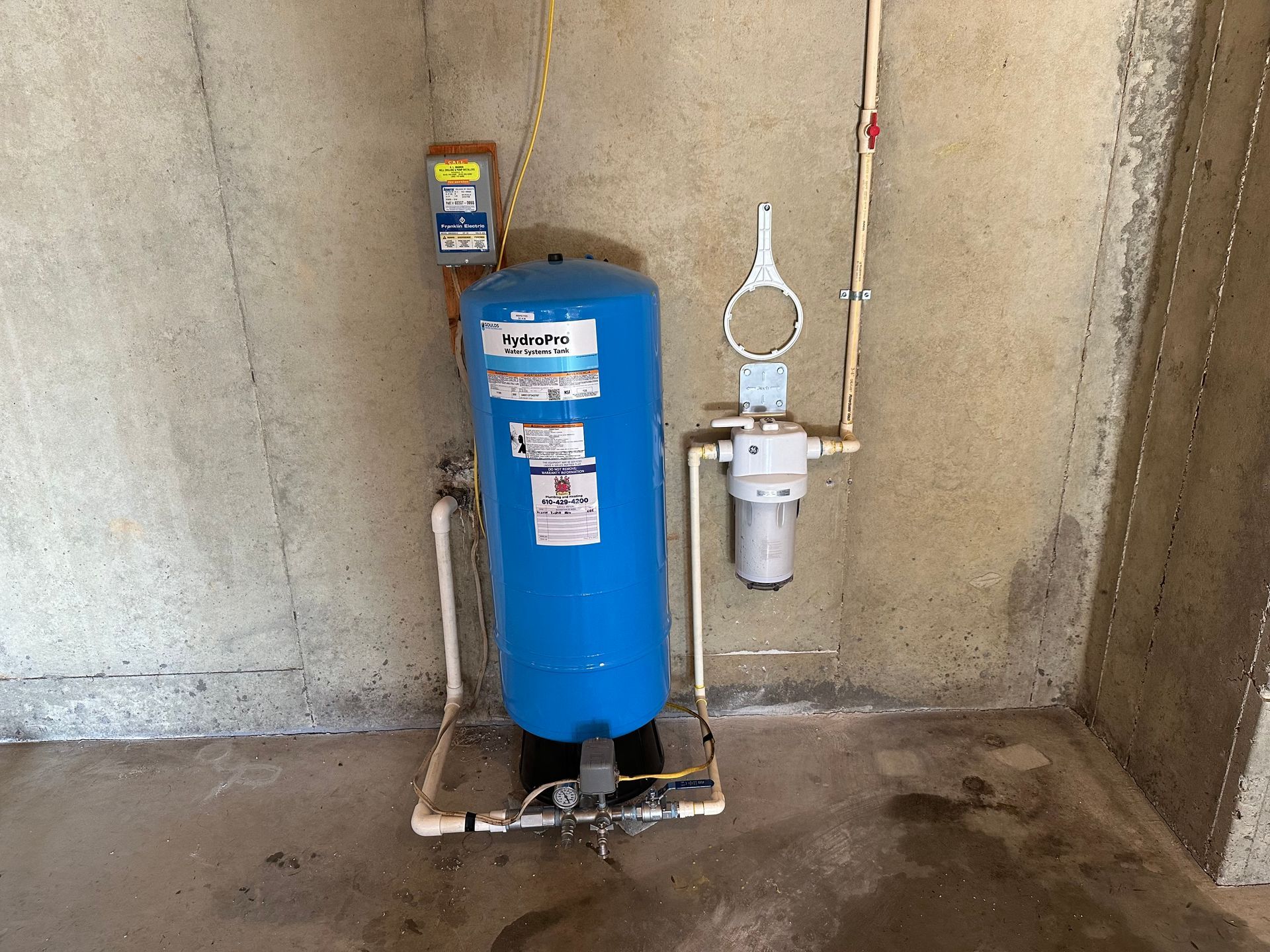 A blue water tank is sitting in a room next to a wall.