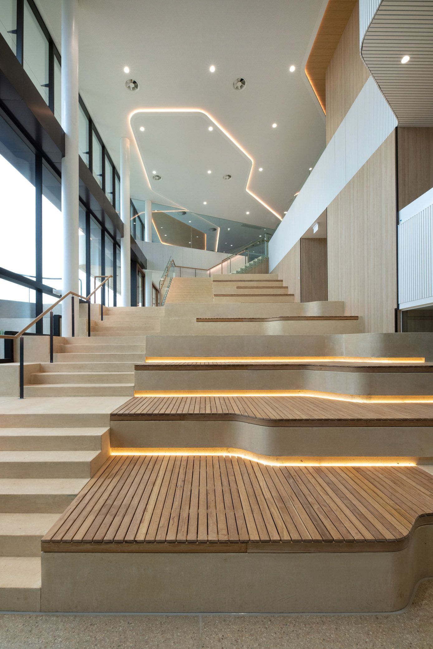 A set of stairs in a building with a wooden floor.