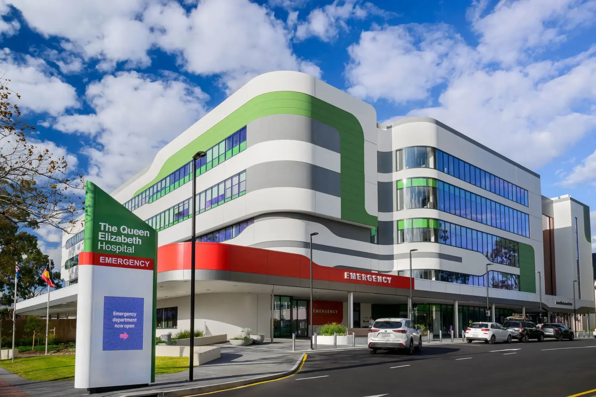 A large building with a lot of windows and cars parked in front of it.
