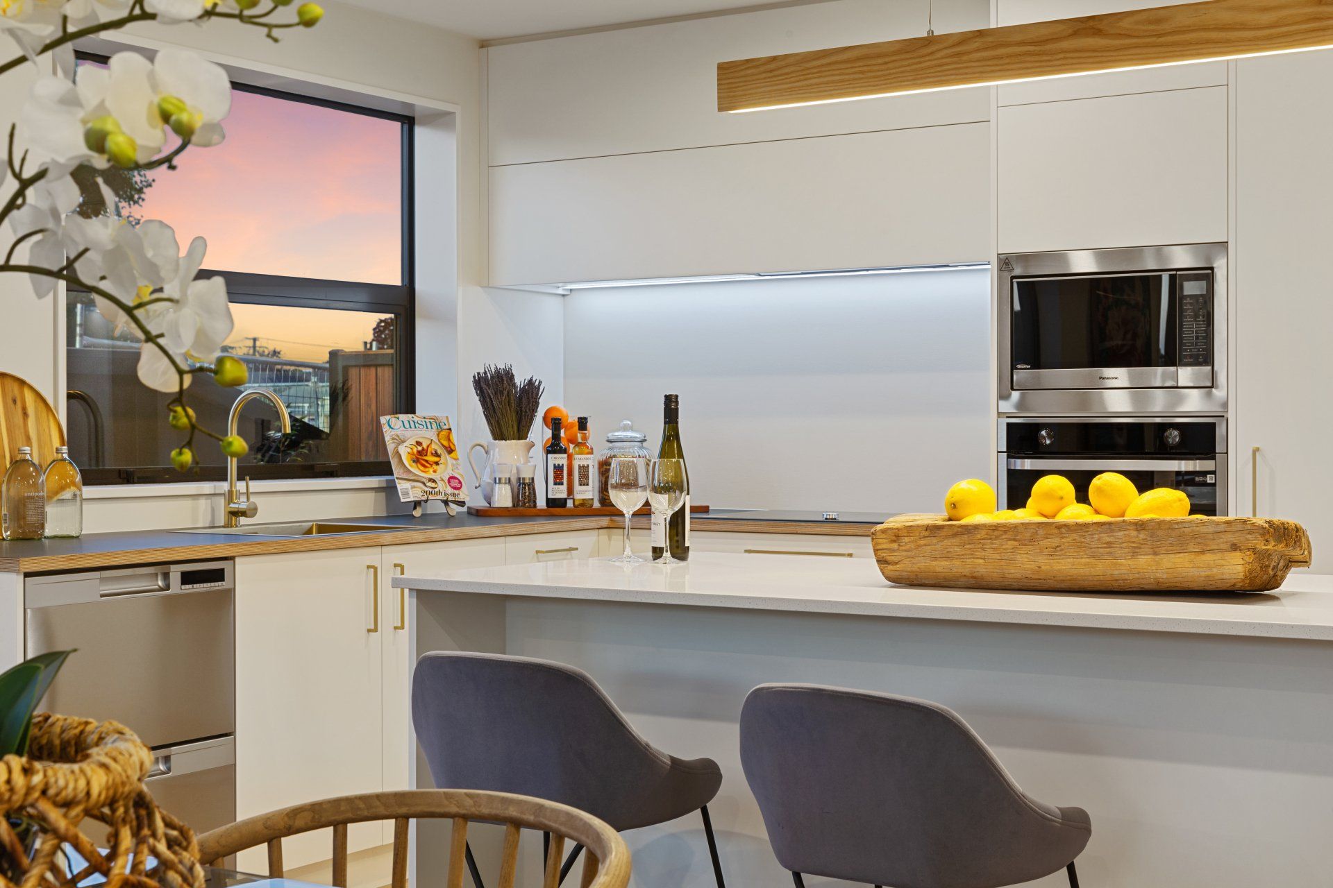A kitchen with a tray of lemons on the counter.