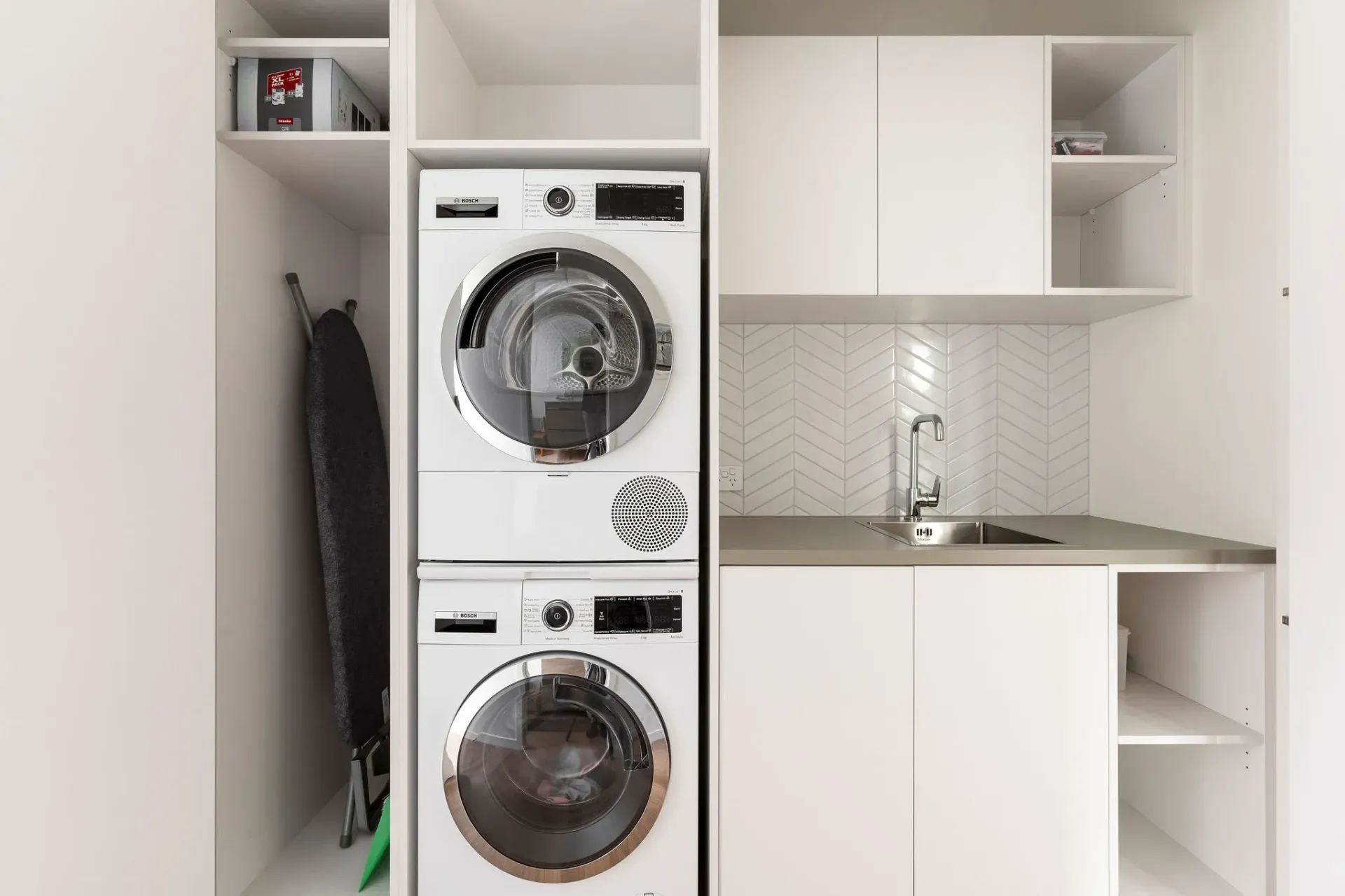 A washer and dryer are stacked on top of each other in a laundry room.