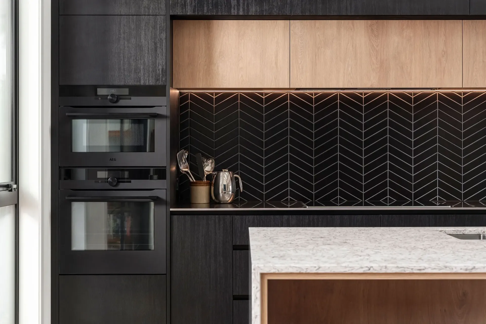 A kitchen with black cabinets and a white counter top.