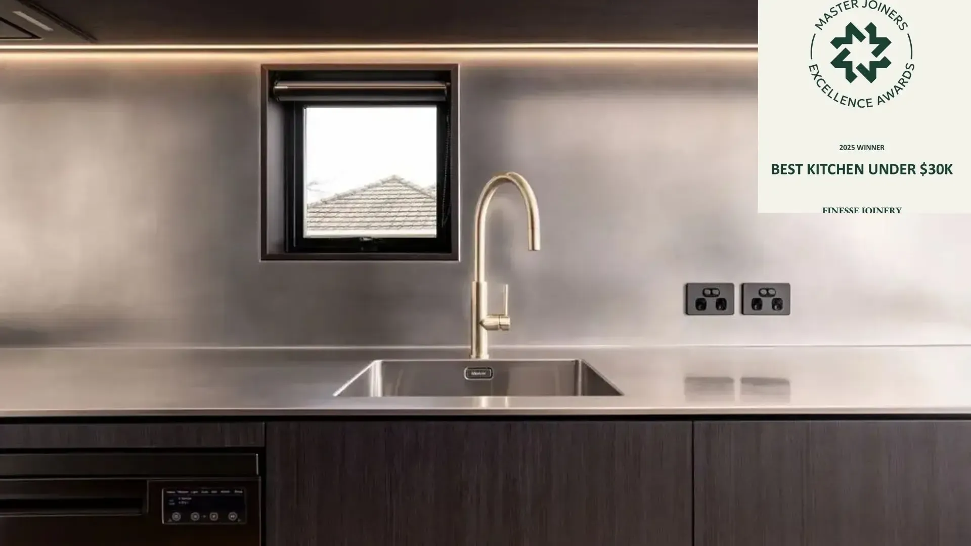 Modern kitchen with gold faucet, stainless steel sink, and dark wood cabinets.