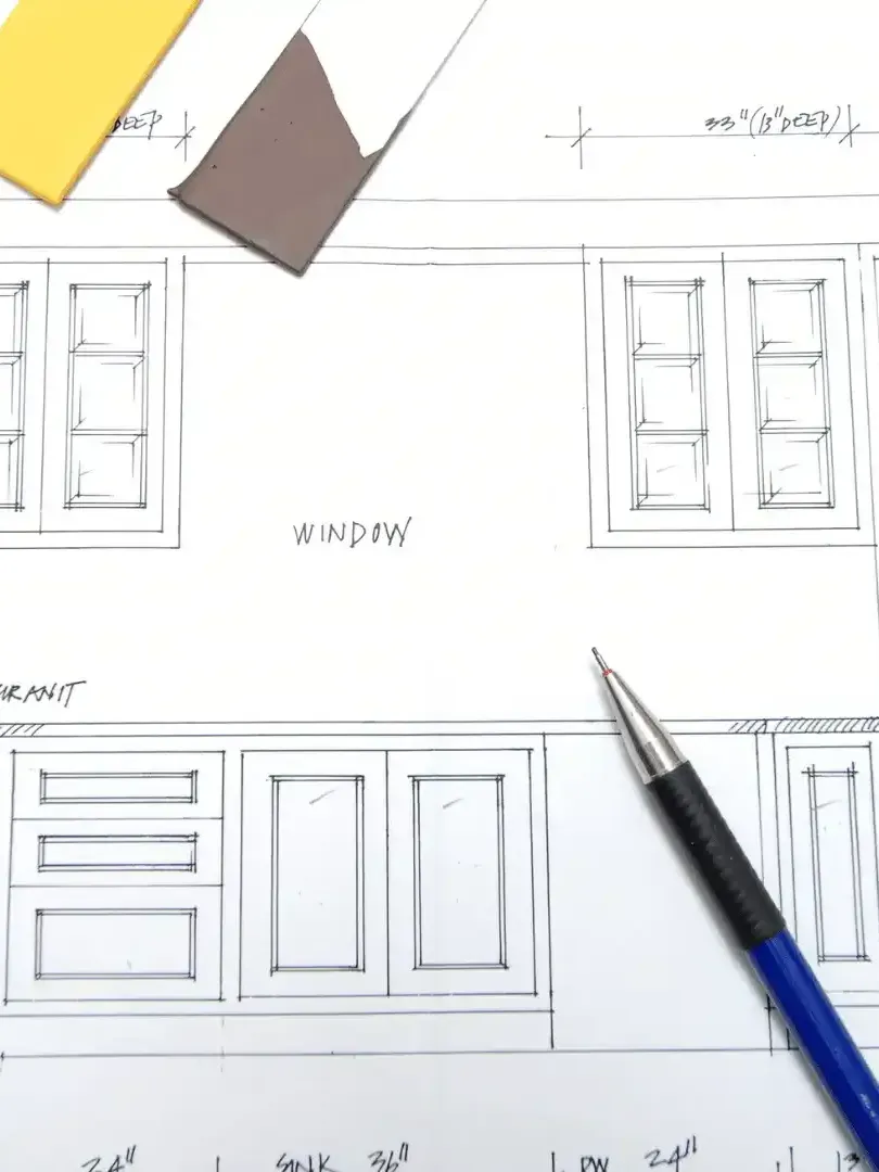 A blue pen is sitting on top of an initial drawing for a new kitchen design