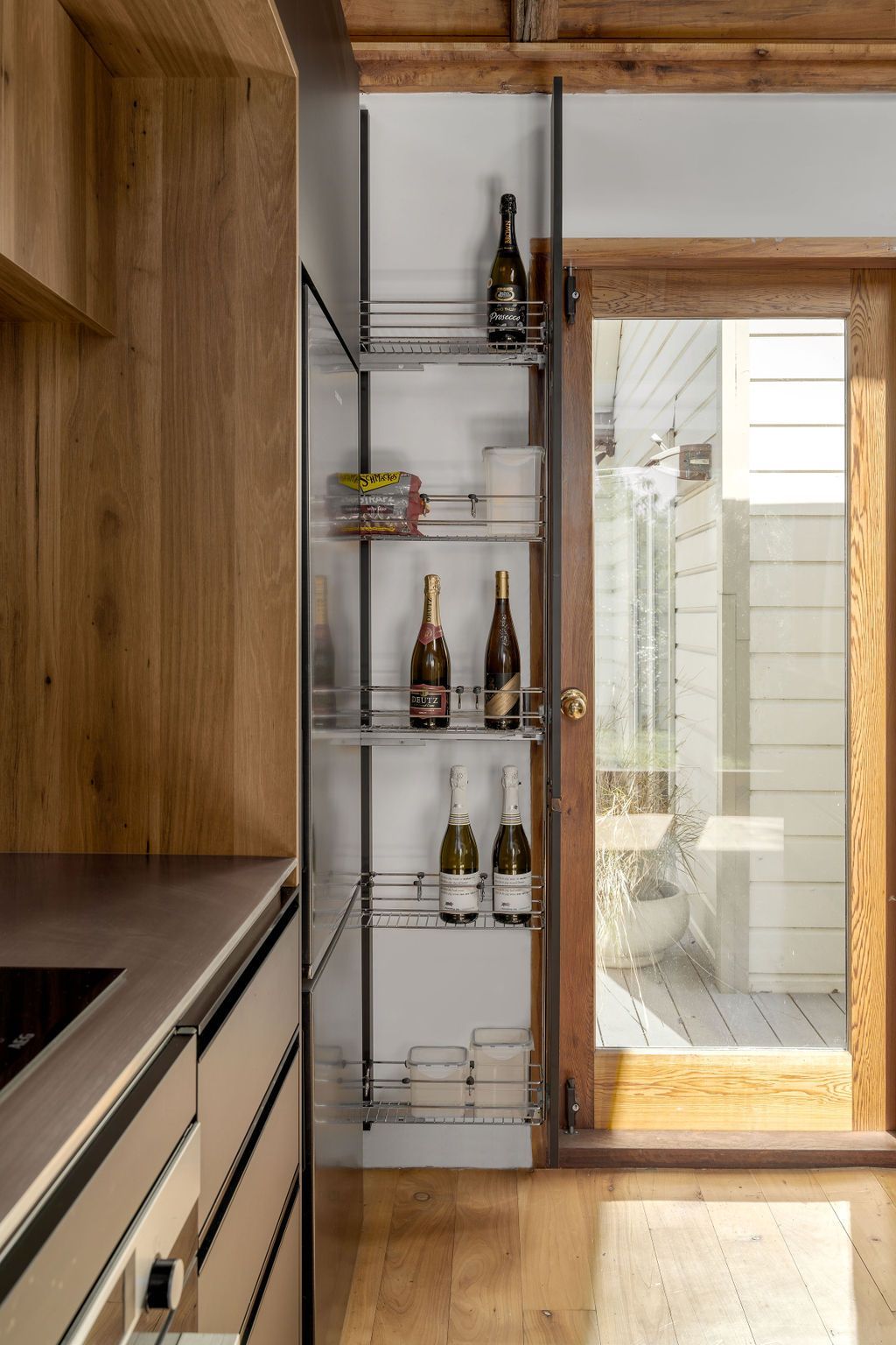 A kitchen with a pantry filled with bottles of wine.