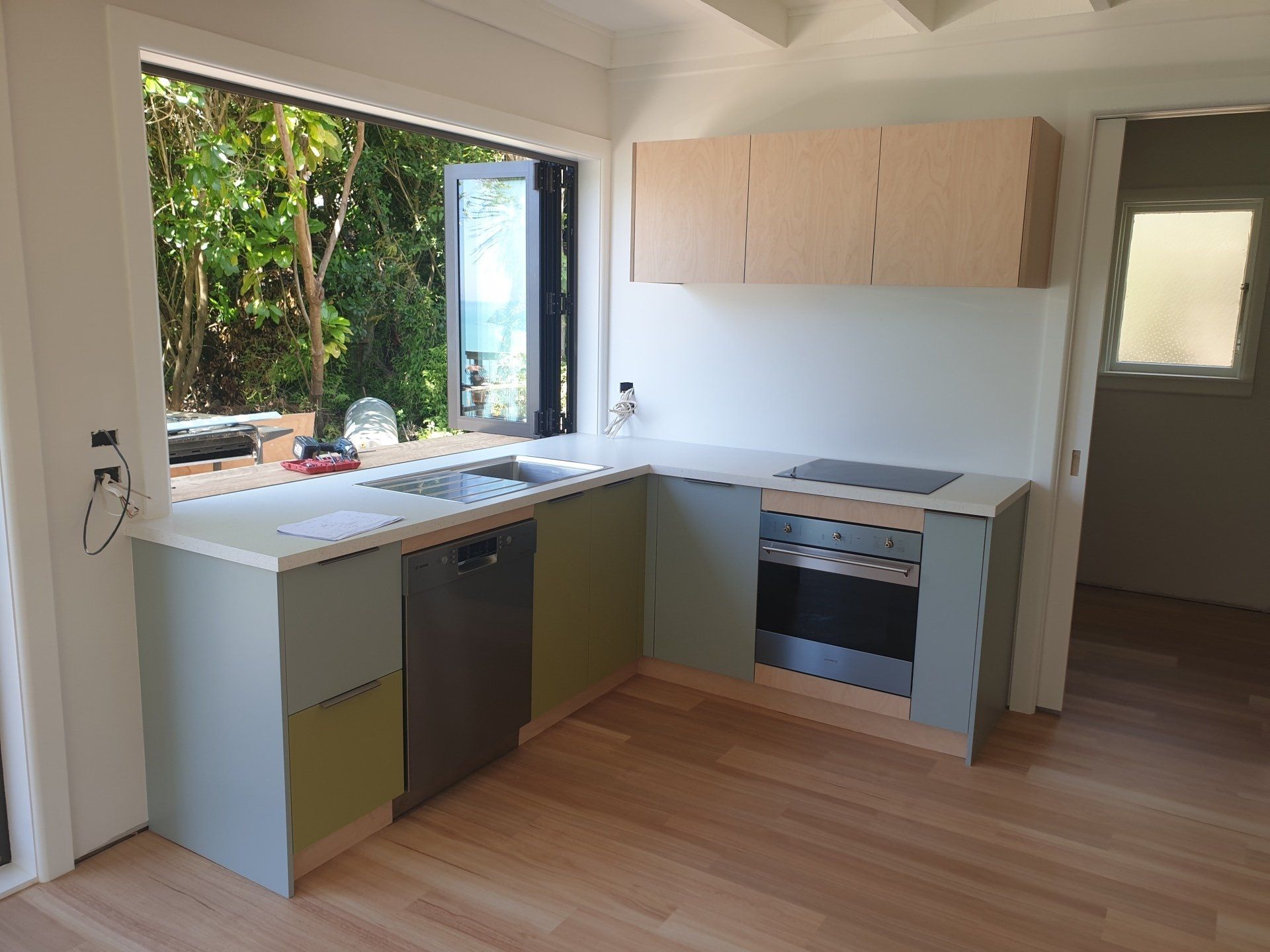A kitchen with a sink , stove , dishwasher and window.