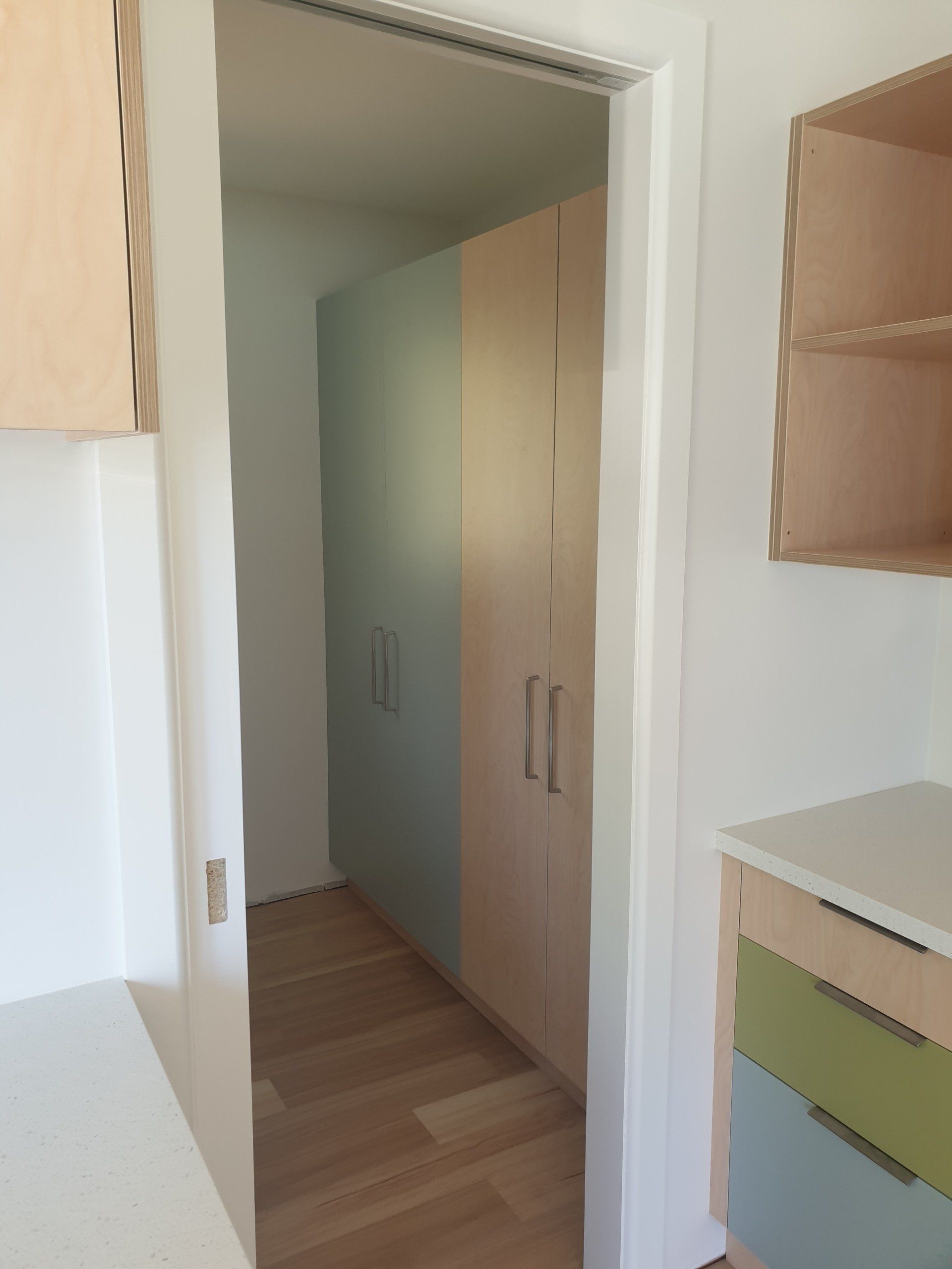 A kitchen with a sliding glass door leading to a hallway