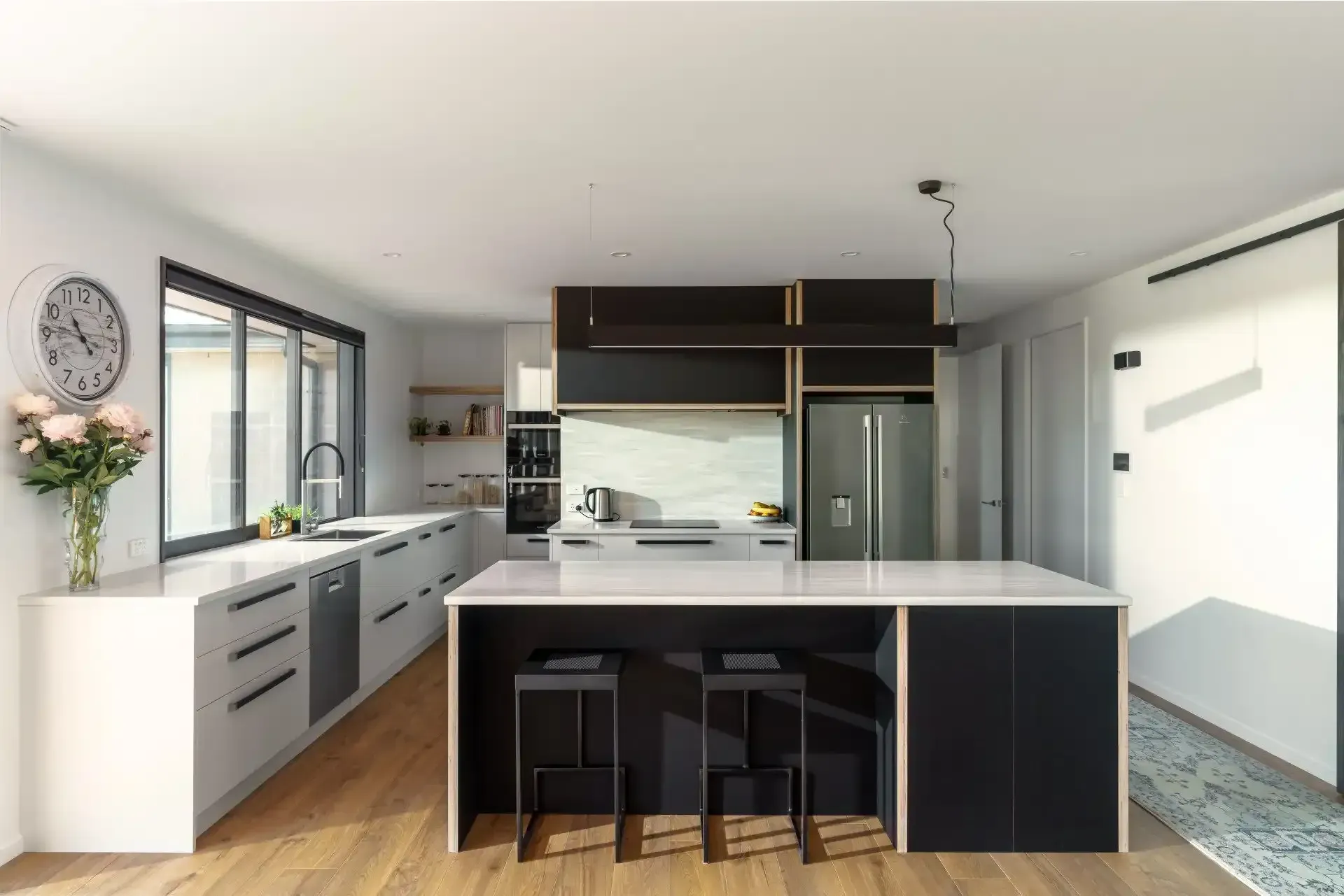 A kitchen with a large island and a clock on the wall.