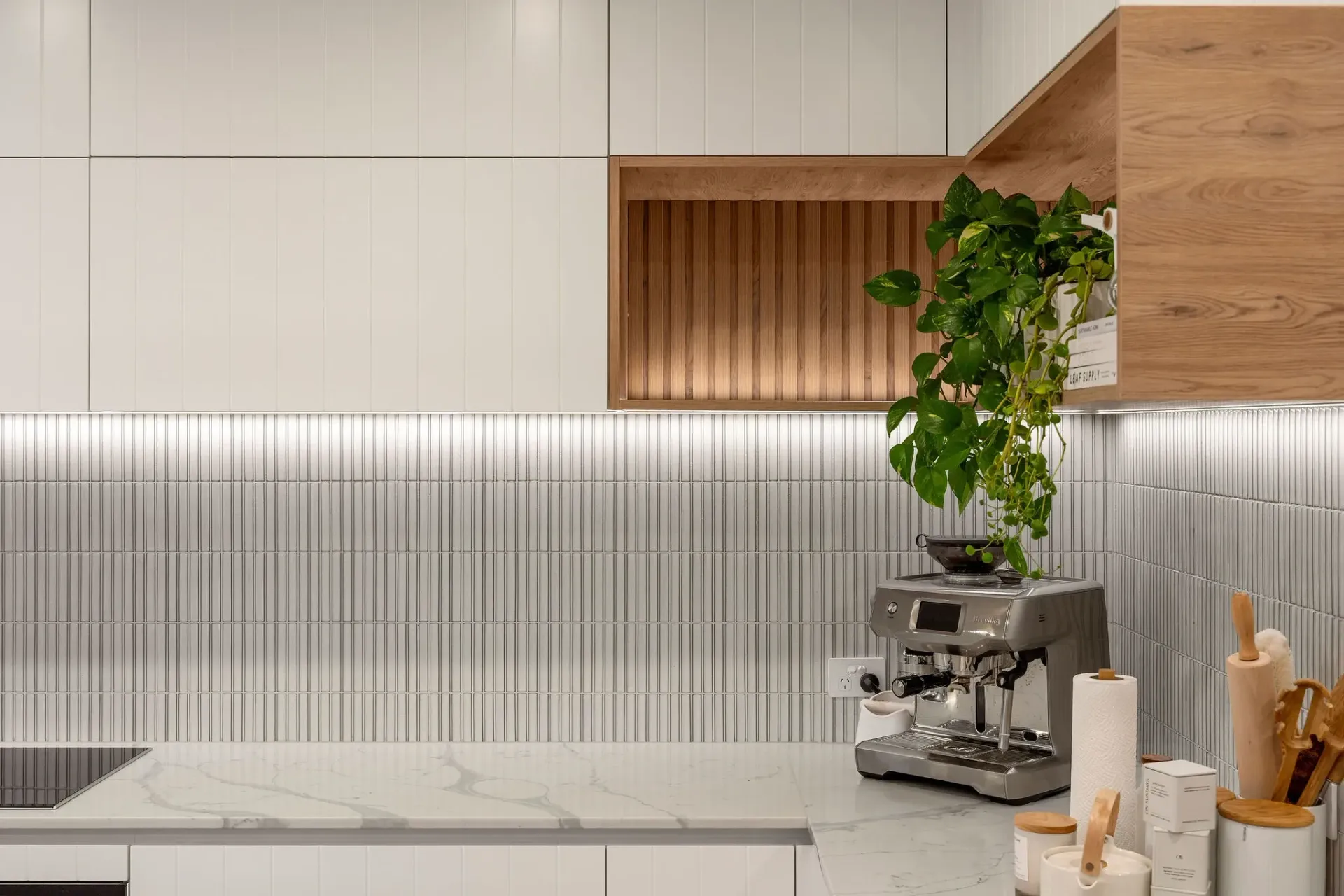 A kitchen with white cabinets and a coffee maker on the counter.