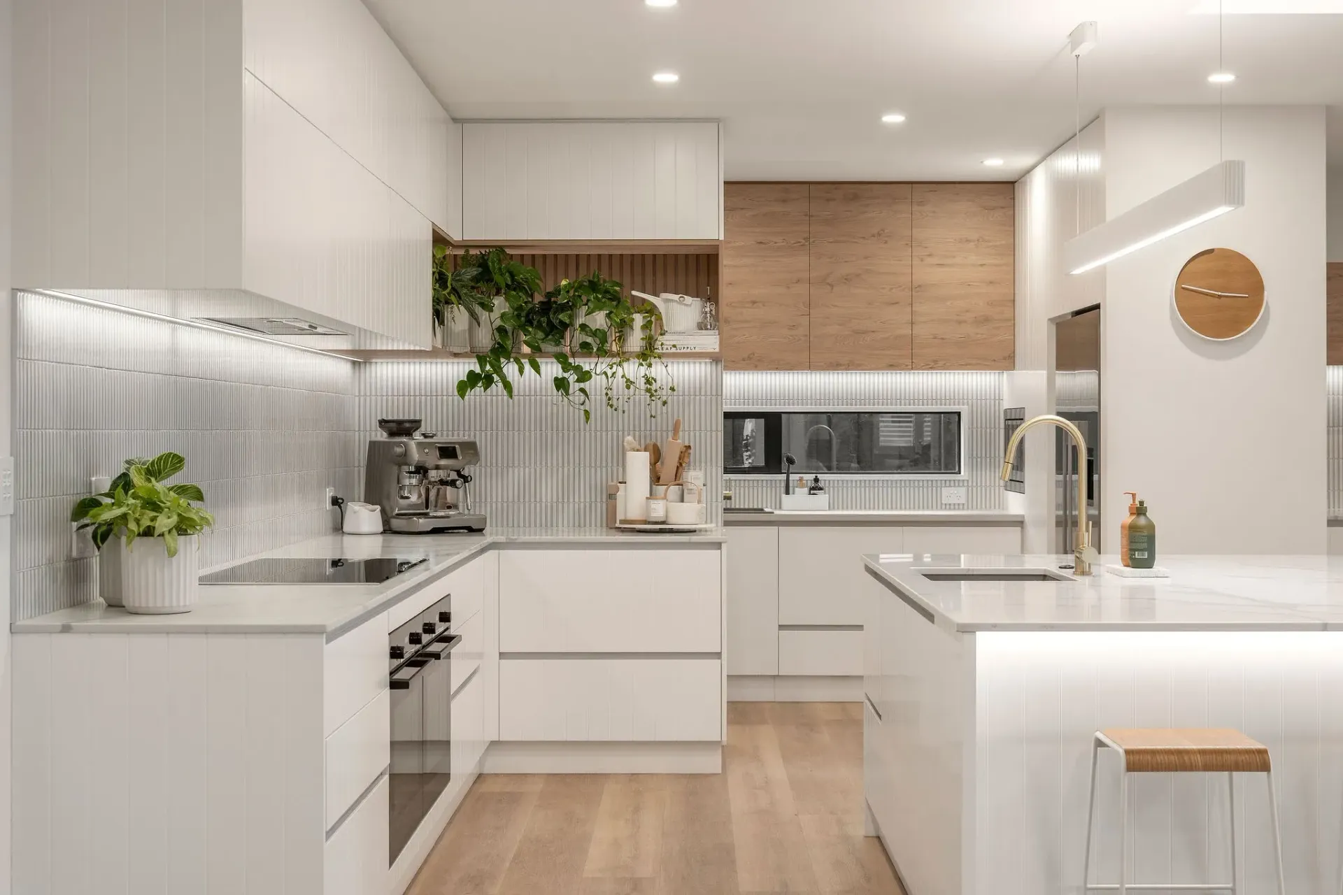 A kitchen with white cabinets , stainless steel appliances , and a large island.