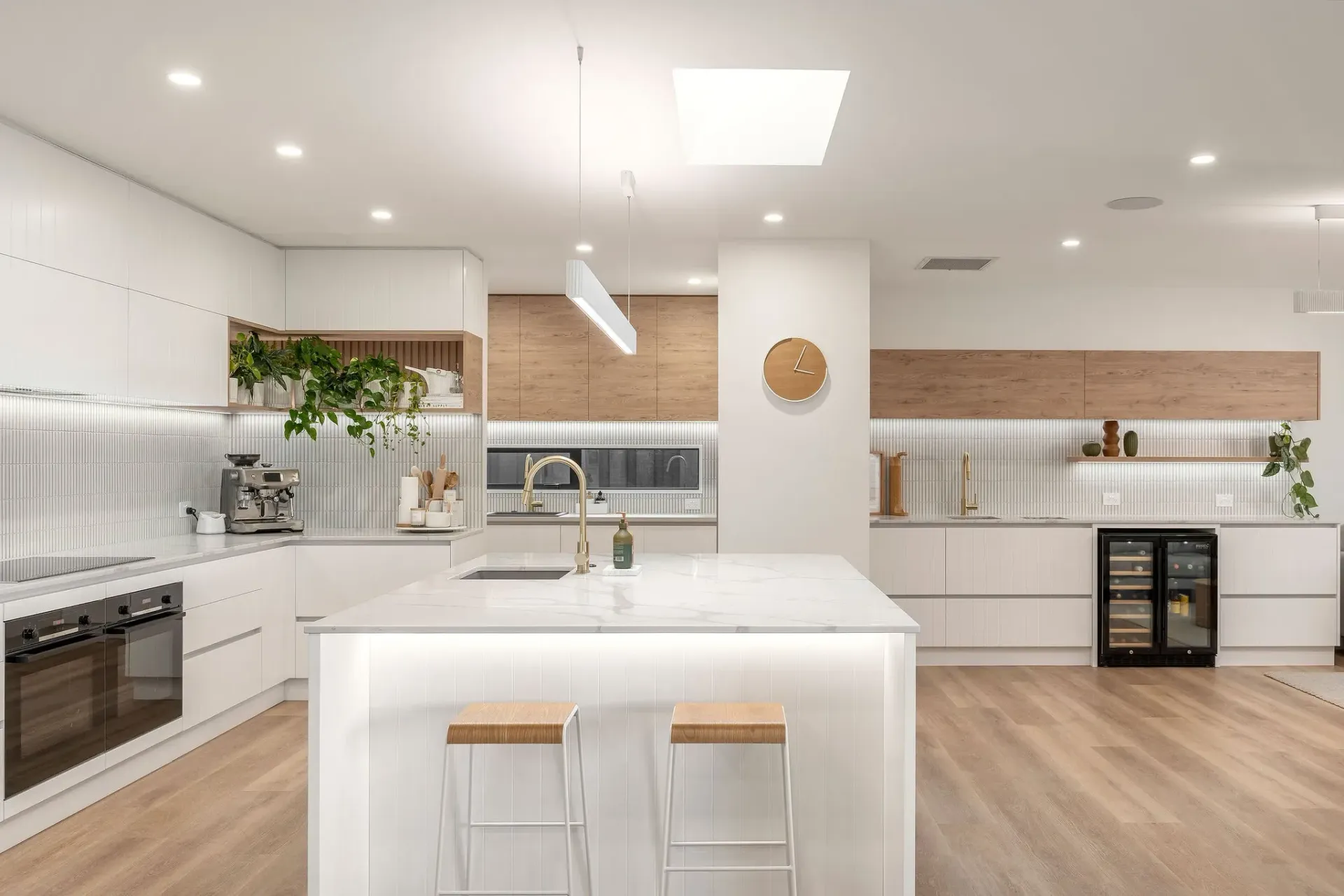 A kitchen with white cabinets and a large island in the middle.