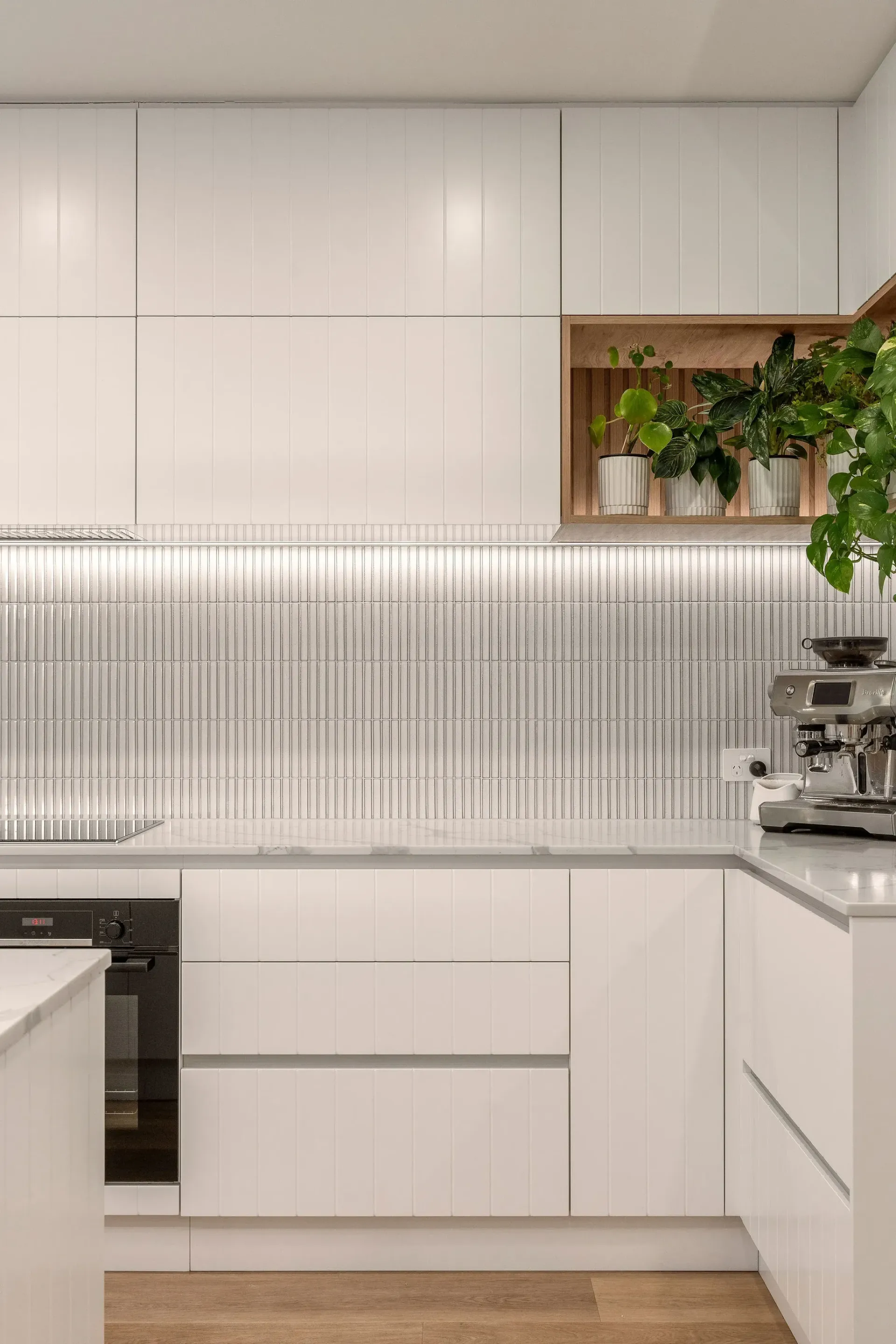 A kitchen with white cabinets and a coffee maker.